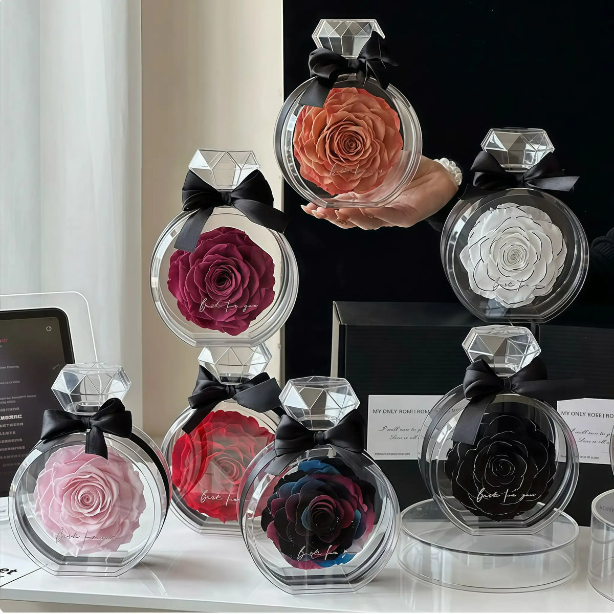 LULU ROSÉE Single Rose Perfume Bottle collection with preserved roses displayed on a vanity.