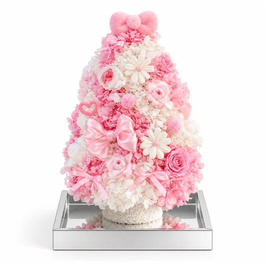 Pink and white preserved hydrangea Christmas tree with roses and a pink bow on a white background.