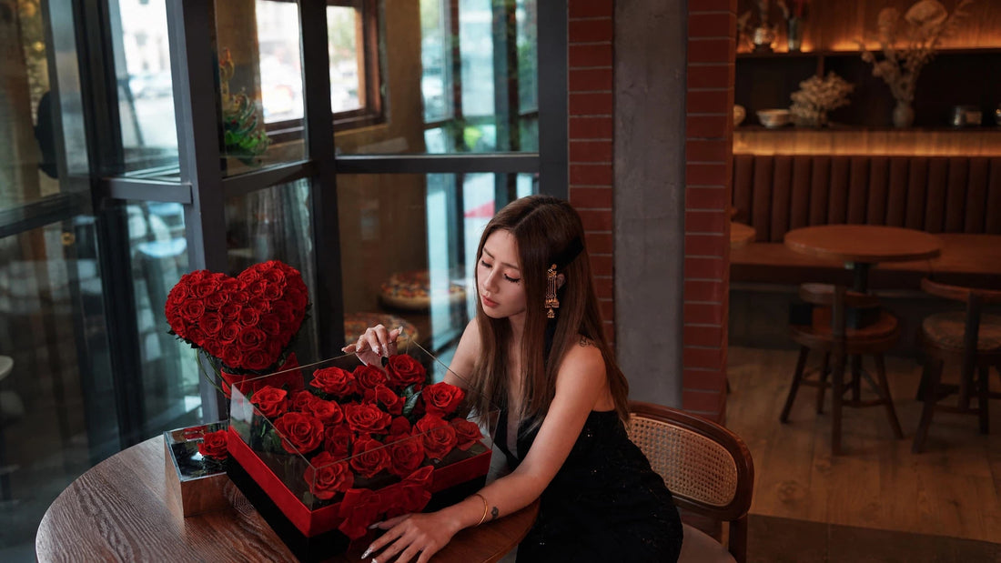 Young woman with LULU ROSÉE red heart-shaped preserved rose acrylic box at cafe, luxury thoughtful romantic flower surprise gift for girlfriend, anniversary & date present ideas