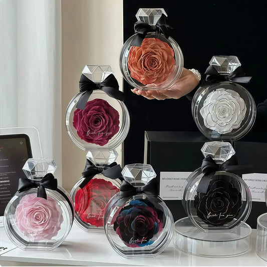 Preserved single roses in colorful perfume-bottle keepsakes arranged on a vanity.