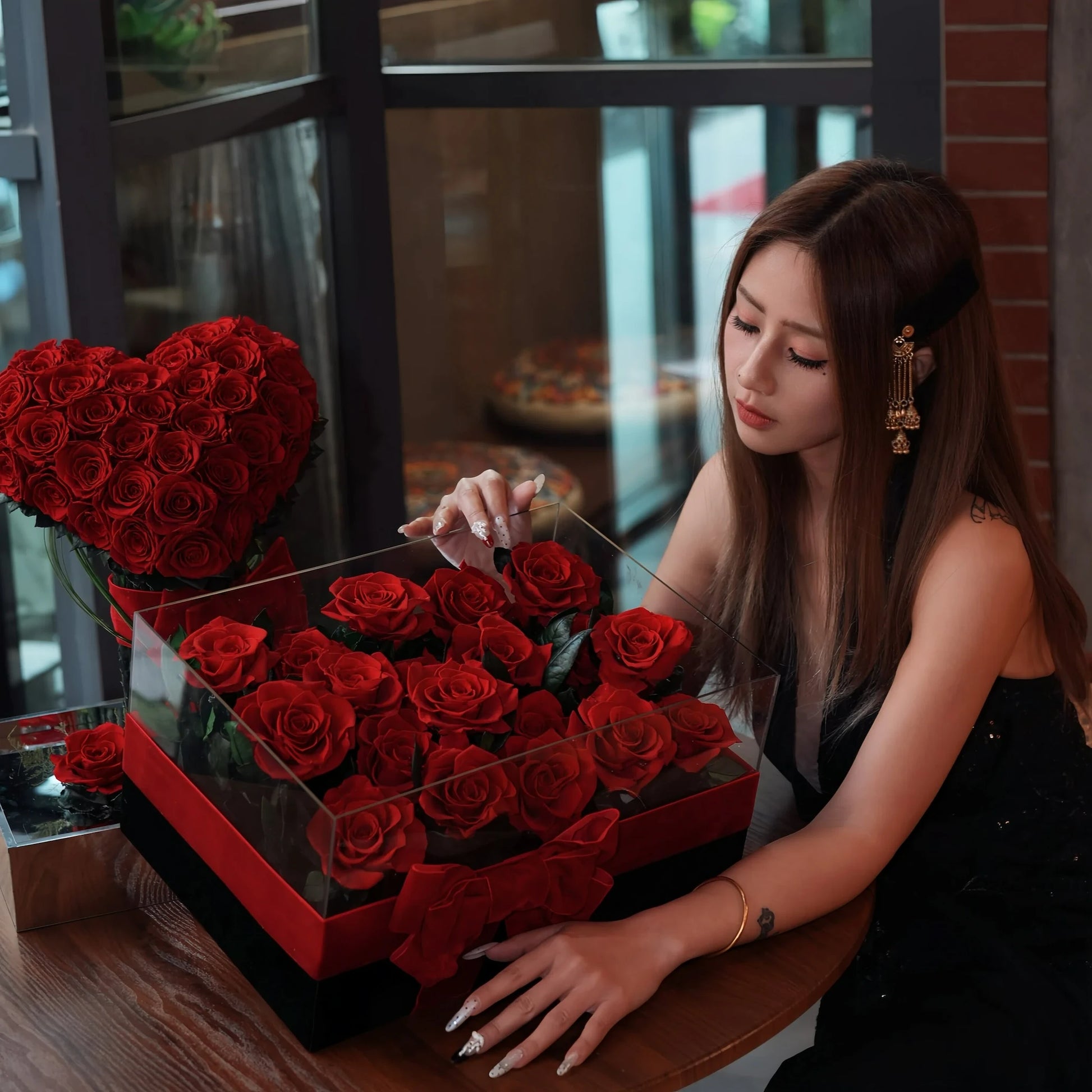LULU ROSÉE Eternal Rose Garden 19 Roses and Heart Bouquet with Model at Restaurant Table