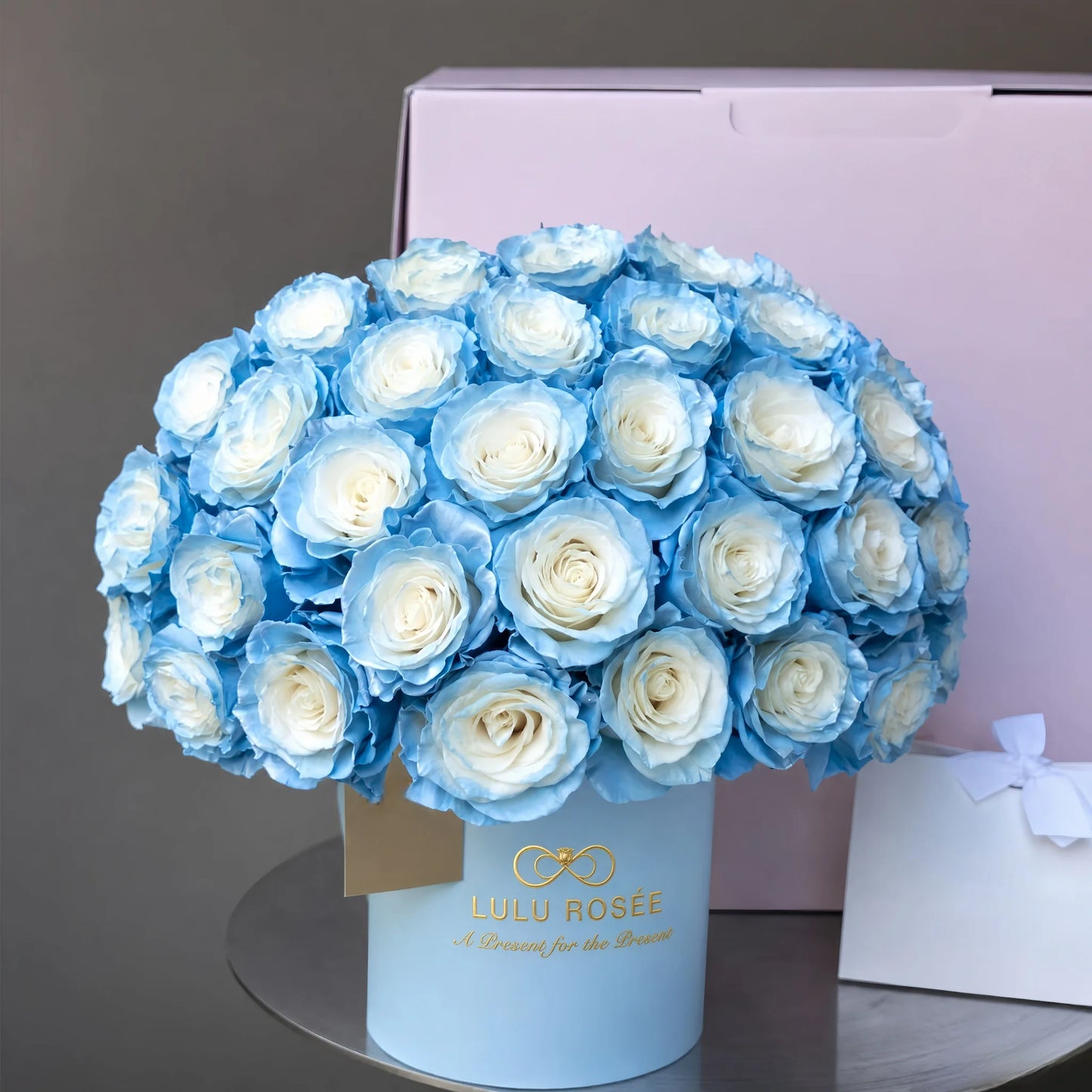 LULU ROSÉE Grande Superdome Ice Blue Gradient Preserved Rose Box paired with light pink gift bag, complete premium preserved rose gift set for birthdays and anniversaries