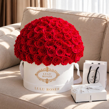 Red preserved roses in a white LULU ROSÉE Large Le Plein box with fragrance gifts.