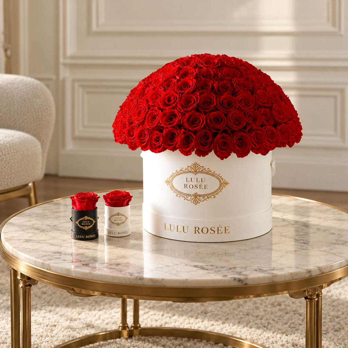 Red preserved roses in a white LULU ROSÉE Large Le Plein box in a sunlit room.