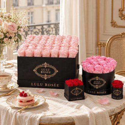 Light pink preserved roses in a black LULU ROSÉE square box styled on an elegant table with matching arrangements.