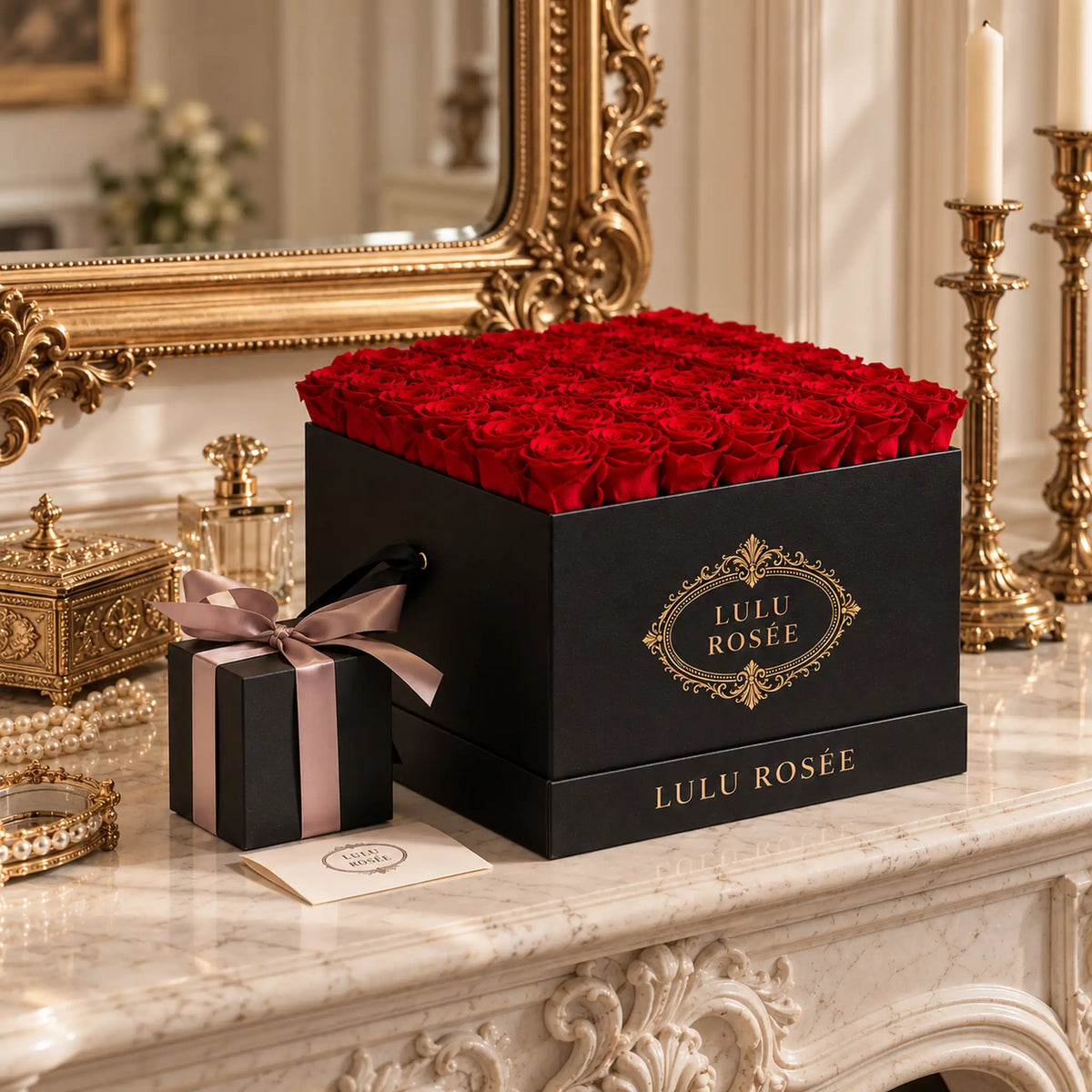 A black classic LULU ROSÉE large square box filled with red preserved roses in an ornate room.