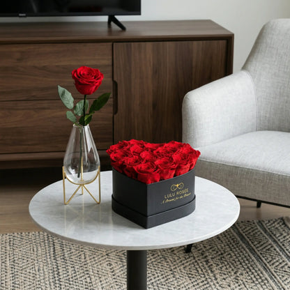 LULU ROSÉE medium heart box red roses black classic box on a marble table in a living room