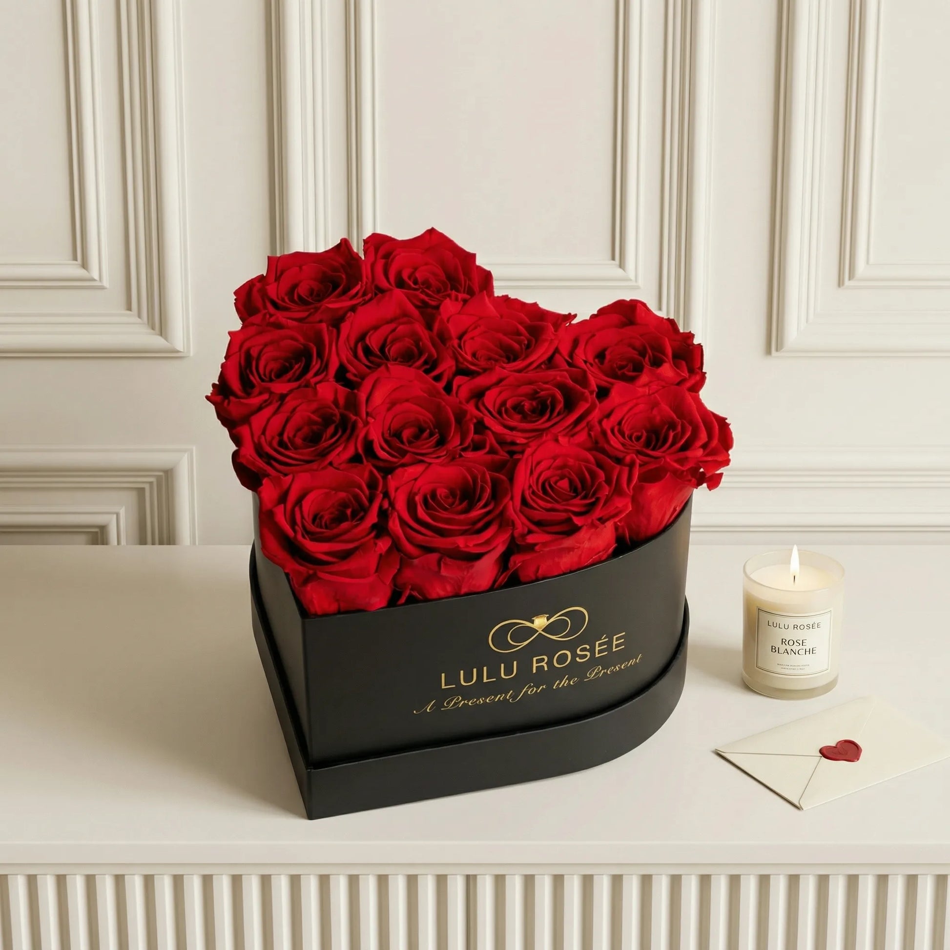 LULU ROSÉE medium heart box red roses black classic box on a white surface