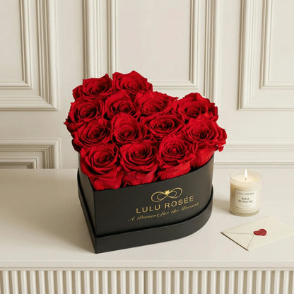 LULU ROSÉE medium heart box red roses black classic box on a white surface