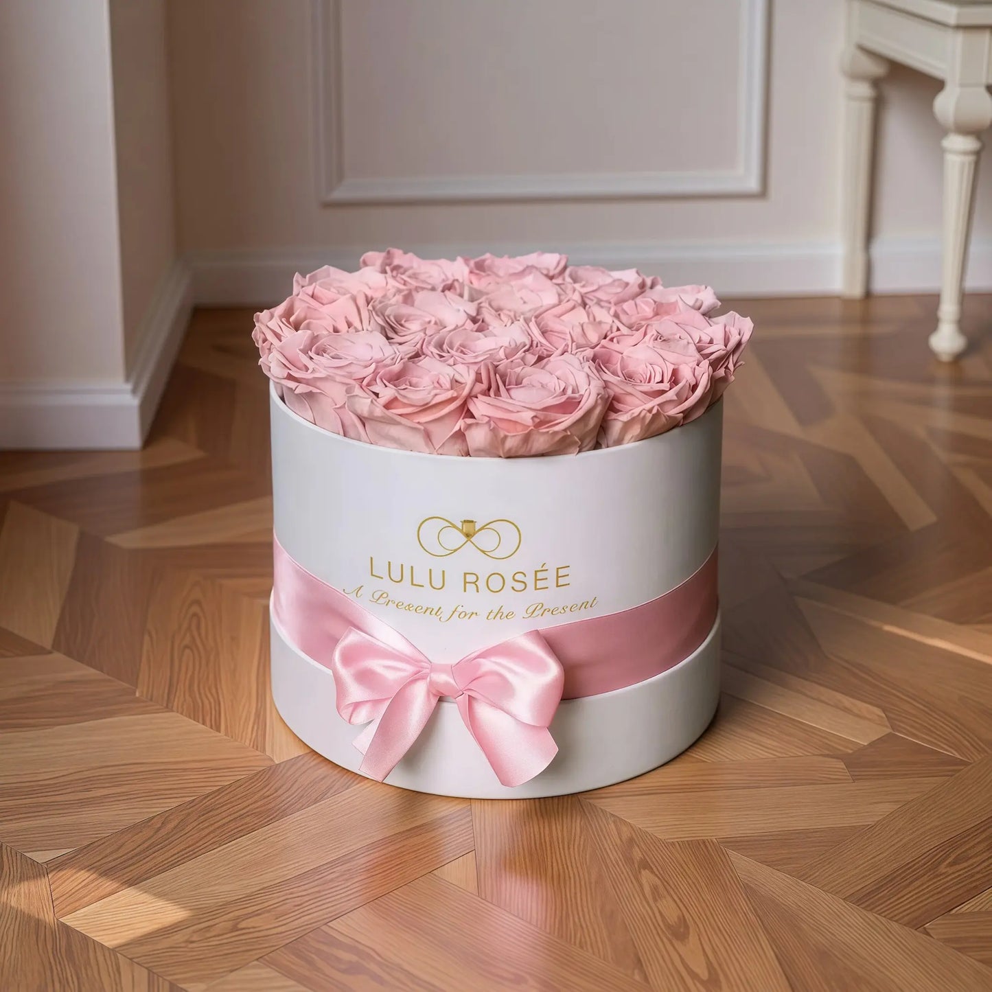 LULU ROSÉE medium round box light pink roses white classic box on a wooden floor