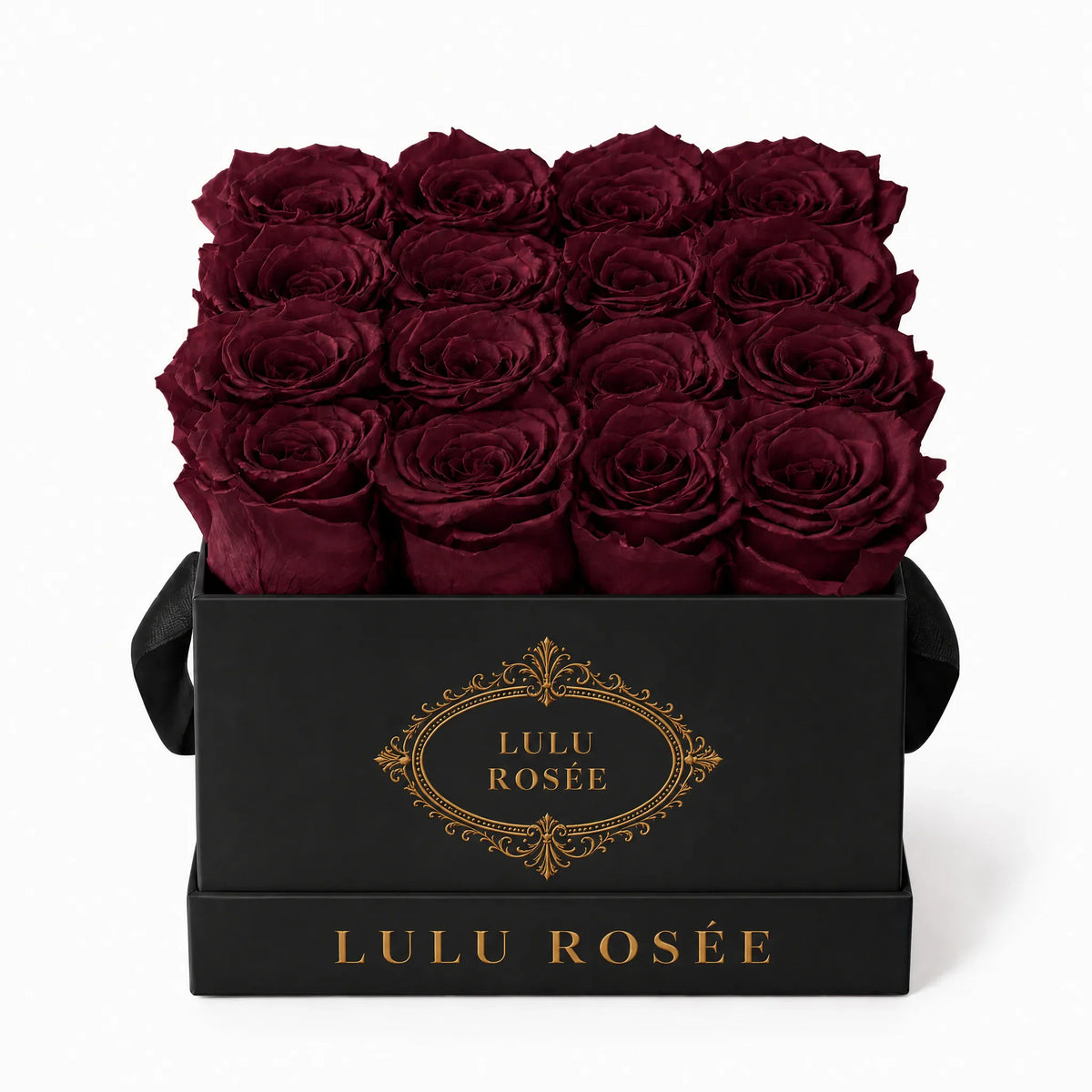 Burgundy preserved roses in a black classic LULU ROSÉE medium square box on a white background.