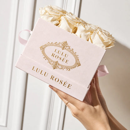 Blush suede LULU ROSÉE medium square rose box with gold logo and satin ribbon detail.