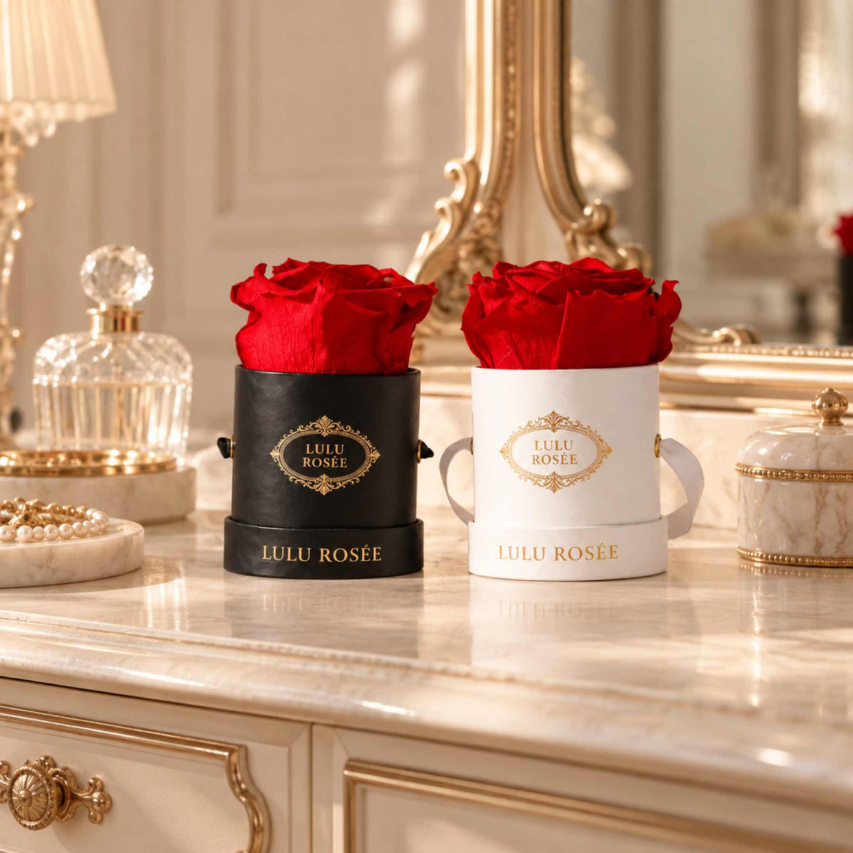 Red eternal roses in black and white Mini Round boxes on a luxury vanity.