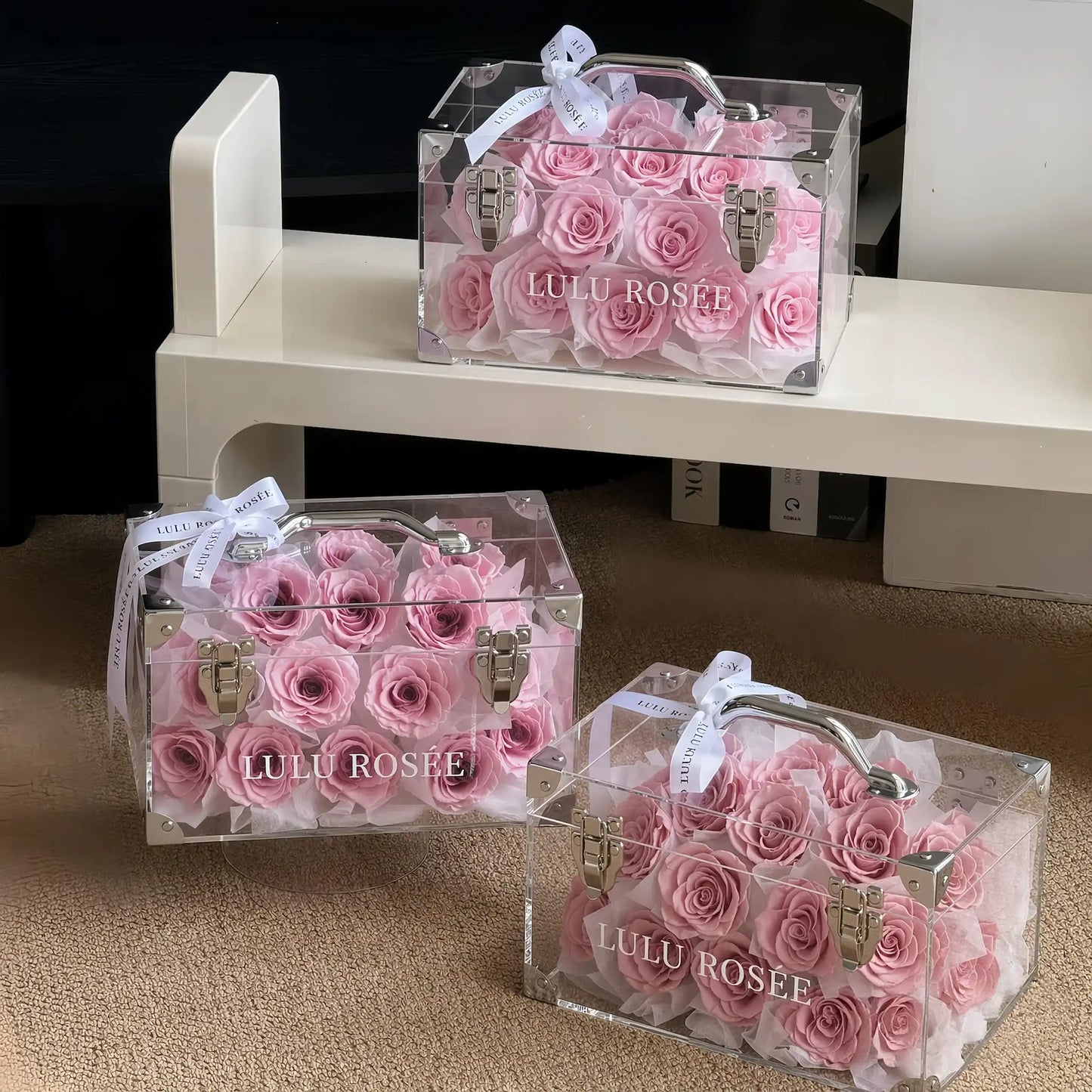 LULU ROSÉE Petite Eternal Acrylic Handbag Rose Box, small transparent acrylic handbag-shaped gift box filled with blush pink preserved roses, three boxes minimalist shelf styling display, customizable flower color options, mini luxury everlasting floral souvenir for birthday, anniversary & romantic gift giving