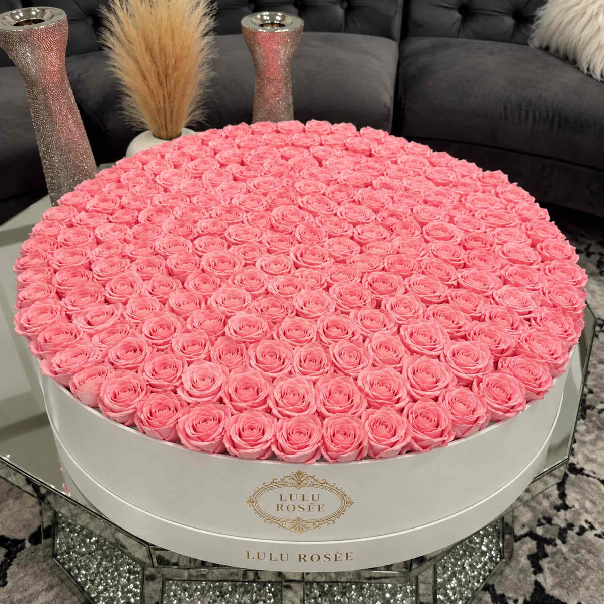 Light pink eternal roses in a White Classic grand round box displayed in an interior