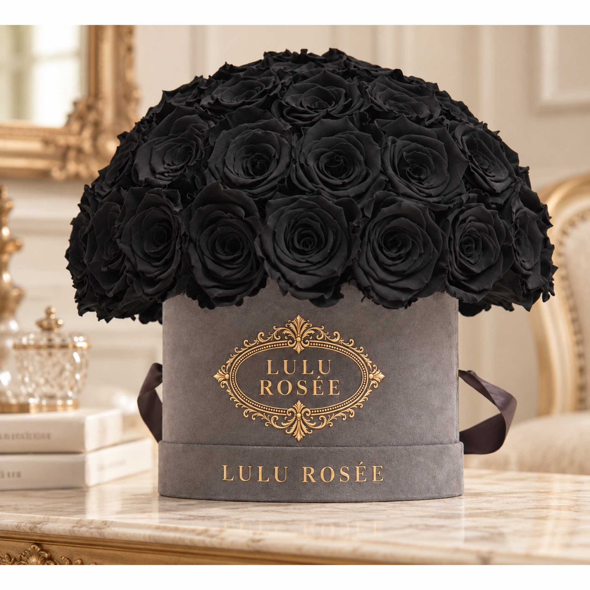 Black preserved roses in a grey suede Small Le Plein box in an elegant interior.