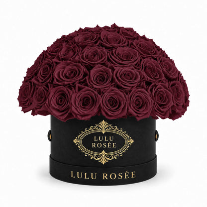 Burgundy preserved roses in a black classic Small Le Plein box on a white background.