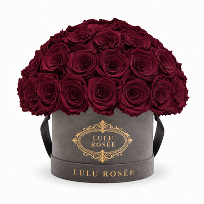 Burgundy preserved roses in a grey suede Small Le Plein box on a white background.