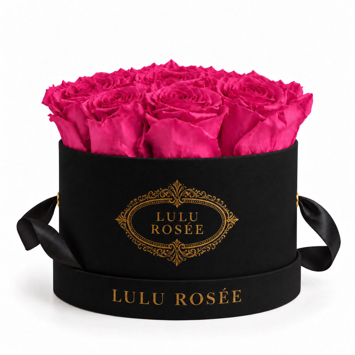 Hot pink preserved roses in a black small round box on a white background.