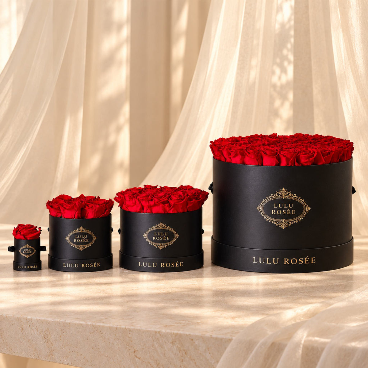 Red preserved rose boxes arranged to show the Small Round Box alongside other sizes.