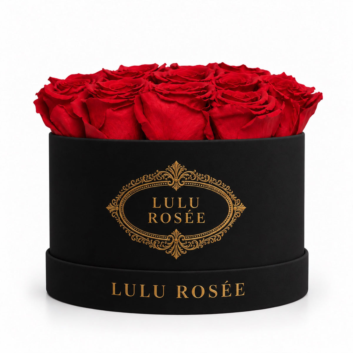 Red preserved roses in a black round box with ornate gold logo detailing.