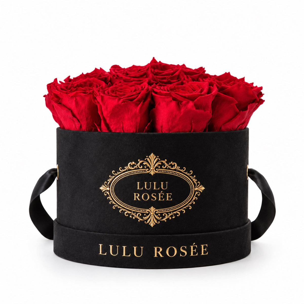Red preserved roses in a black small round box on a white background.