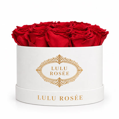 Red preserved roses in a white round box with a gold LULU ROSÉE logo.