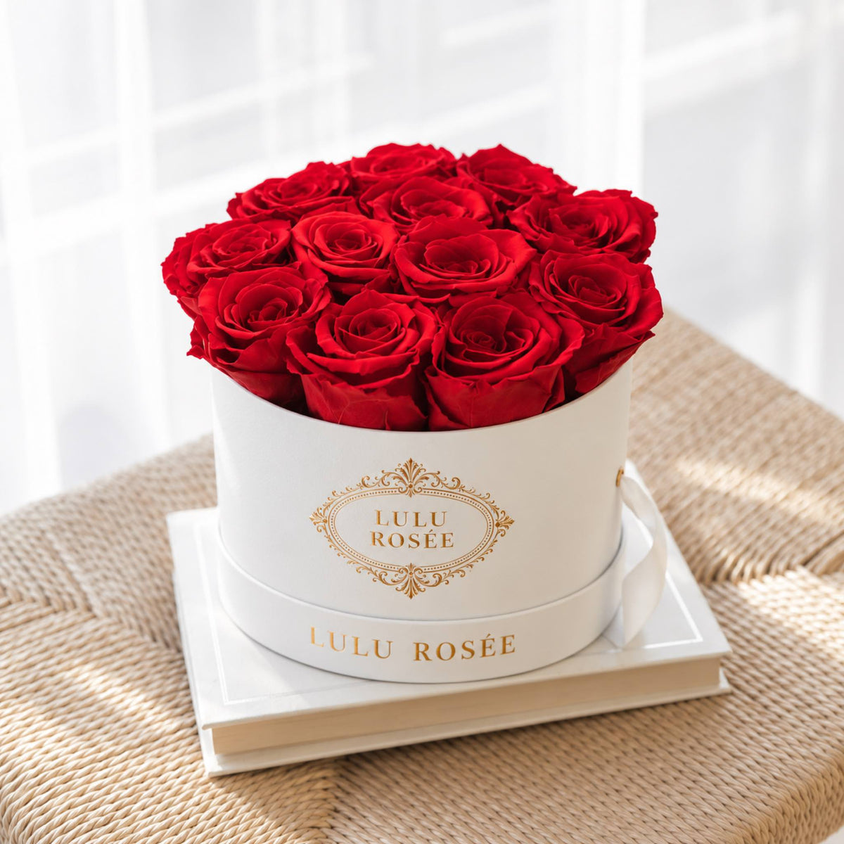 Red preserved roses in a white round box photographed in soft light.
