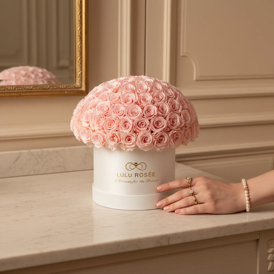 LULU ROSÉE large le plein baby pink roses white box on a wooden surface.