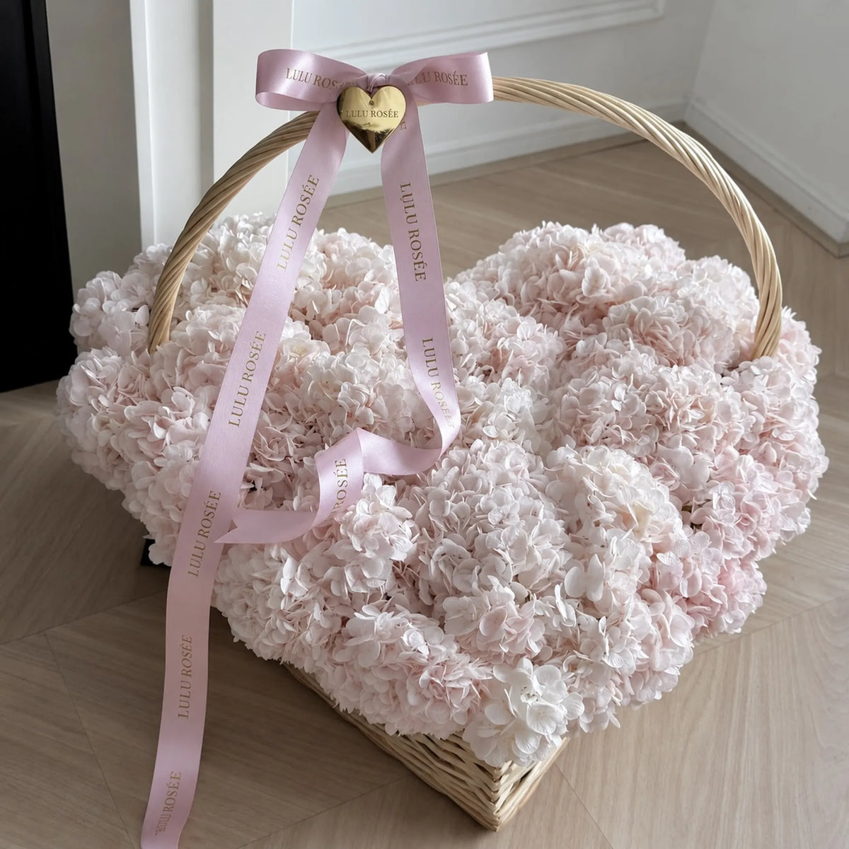 Heart-shaped preserved hydrangea basket with a pink bow and flowing ribbons