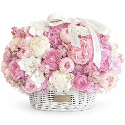 Blush preserved peony, rose and hydrangea basket with white orchids on a white background