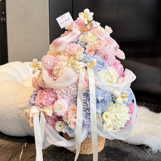 Christmas tree inspired preserved flower gift in a pastel palette beside a cream sofa