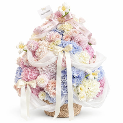 Pastel preserved flower Christmas tree arrangement with white ribbons on a white background
