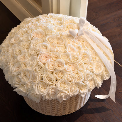 Angled view of cream preserved roses arranged in a large round basket