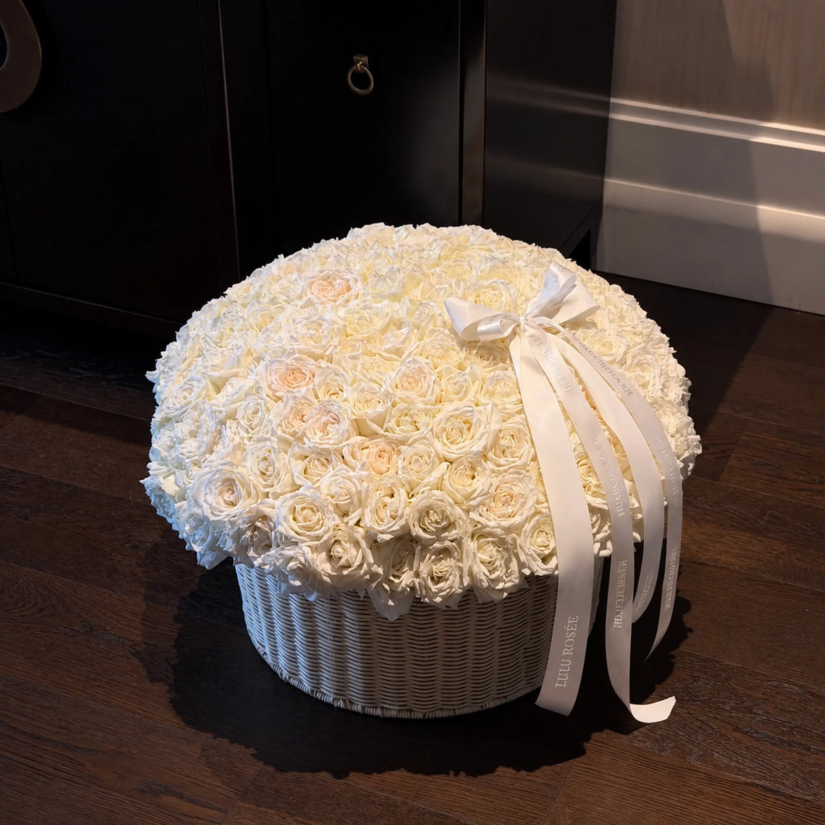 Large cream preserved rose basket in a dimly lit room