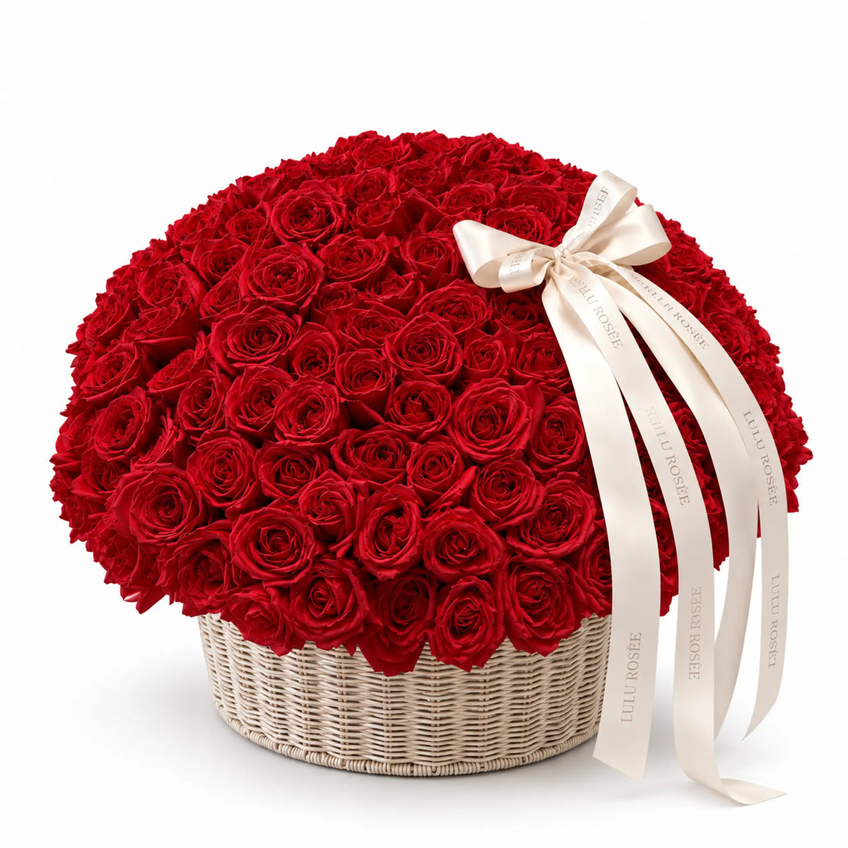 Red preserved roses in a round basket with a white bow on a white background