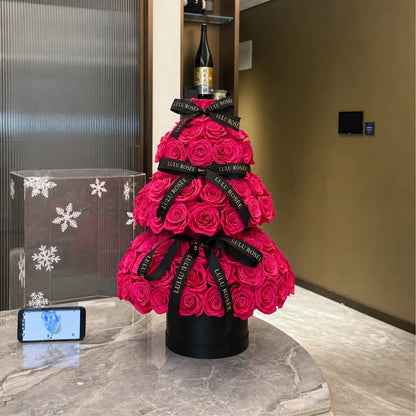 Hot pink preserved rose tree shown in an interior setting with a nearby phone for scale