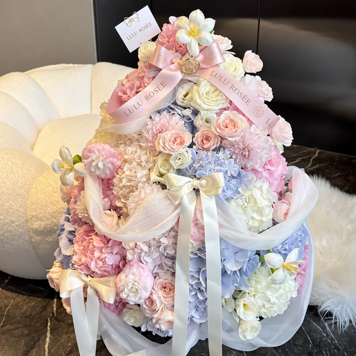 Angled view of a pastel preserved flower tree with pink roses and blue hydrangeas