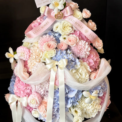 Close view of pink, white and blue preserved flowers in a Christmas tree silhouette