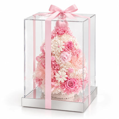 Pink preserved flower Christmas tree in a clear acrylic box tied with a pink ribbon.