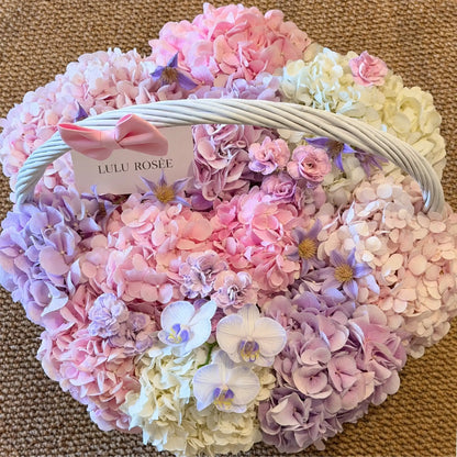 Overhead view of pink and lavender preserved hydrangeas with white orchids