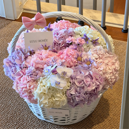 Preserved flower basket in pink and lavender displayed in an interior setting