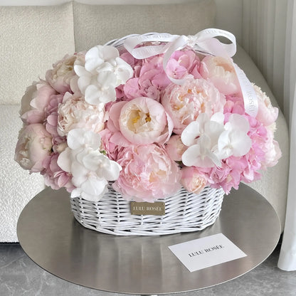 Pastel preserved flower basket with a white ribbon displayed beside a LULU ROSÉE card