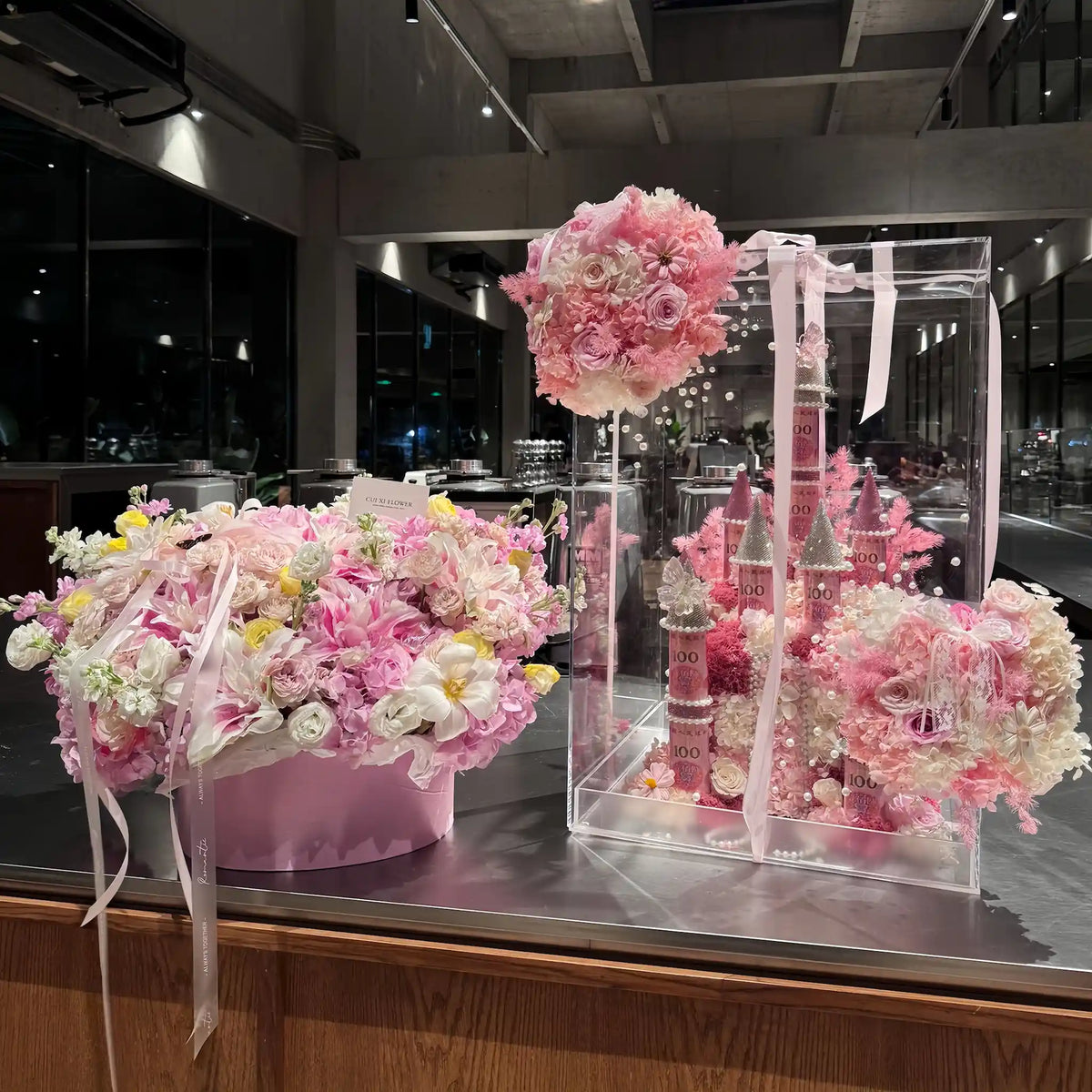 LULU ROSÉE pink medium preserved flower castle display shown with related arrangements