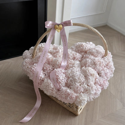 Pink and white preserved hydrangea heart basket displayed in an interior