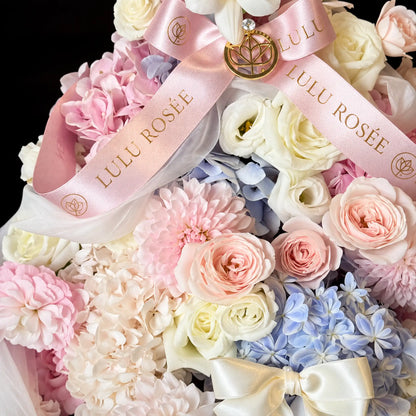 Preserved pink and cream roses with a LULU ROSÉE ribbon and gold-tone ornament