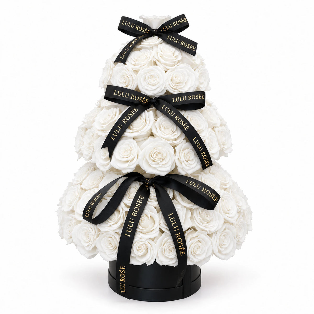 White preserved roses arranged in a three-tier Christmas tree with black ribbons